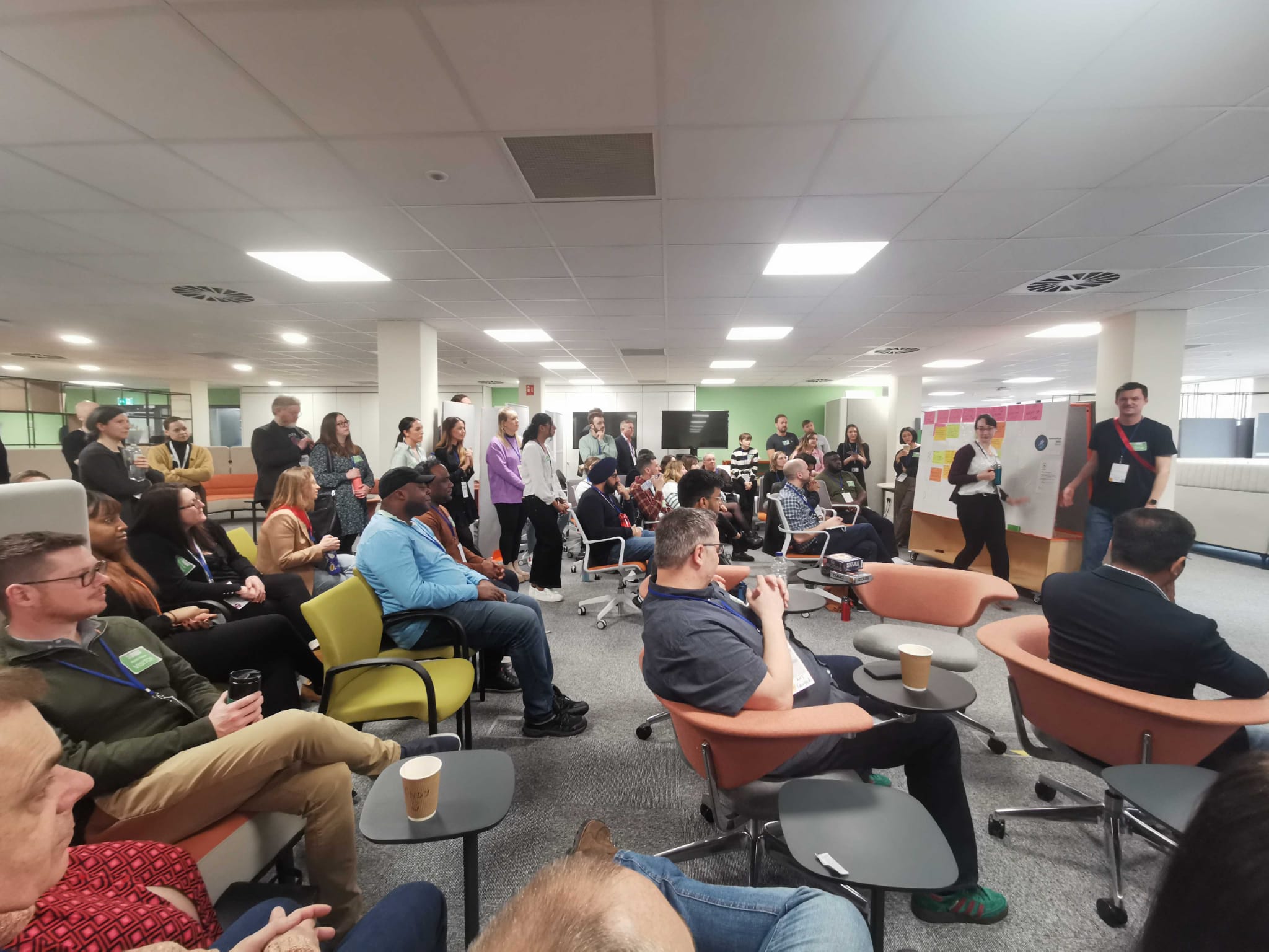 A room of people with some standing pitching ideas for sessions.